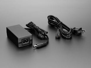 Angled shot of 5V 4A switching power supply brick with power cable.