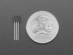 Small, black, analog temperature sensor next to US quarter for scale.