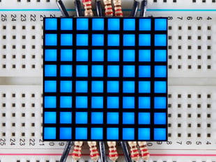 Blue, 8x8, square LED matrix on a half-size breadboard.