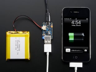 Top view of PowerBoost 500 Charger connected to a battery and a white iPhone charger charging an iPhone. 