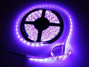 LED strip on a reel emitting purple lights.