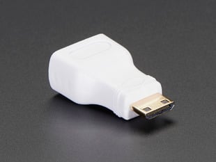 Angled shot of a small, white, mini HDMI to HDMI plug adapter.