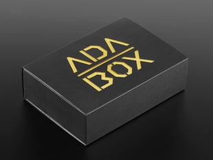 Angled shot of a black box with Yellow "ADABOX" texted logo.