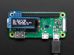 Top view of assembled and powered on Adafruit PiOLED - 128x32 Monochrome OLED on a Pi Zero. The OLED displays a data readout.