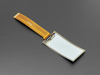 Angled shot of 2.13" monochrome flexible electronic ink display with long ribbon cable.