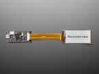 Overhead shot of 2.13" monochrome flexible electronic ink display connected via ribbon cable to a microcontroller. "Monochrome" is in black text.