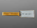 Overhead shot of 2.13" monochrome flexible electronic ink display connected via ribbon cable to a microcontroller. "Grayscale" is in black text.