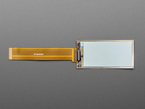 Overhead shot of 2.13" monochrome flexible electronic ink display with long ribbon cable.