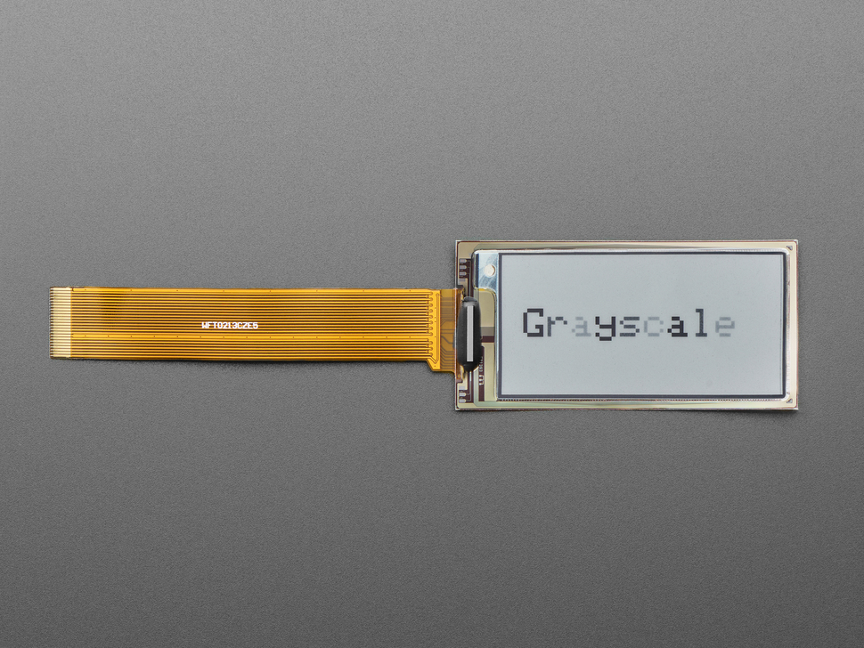 Overhead shot of 2.13" monochrome flexible electronic ink display connected via ribbon cable to a microcontroller. "Grayscale" is in black text.