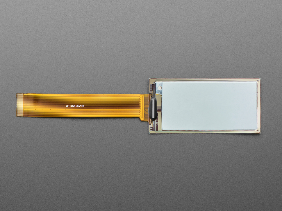 Overhead shot of 2.13" monochrome flexible electronic ink display with long ribbon cable.