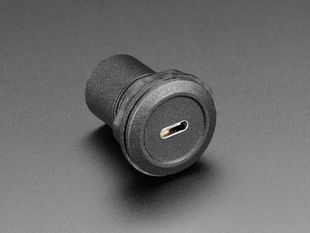 Angled shot of a black, round, panel mount adapter with a USB-C socket.