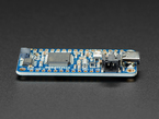 Side detail of STEMMA QT connector on a blue rectangular microcontroller.
