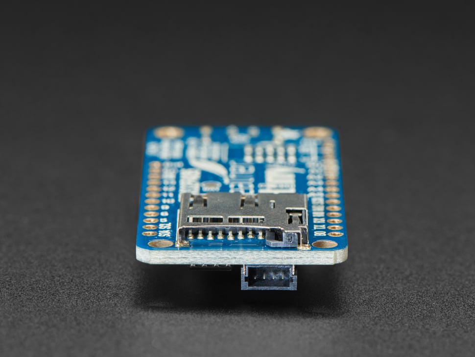 Detailed shot of microSD card holder on a blue rectangular microcontroller. 