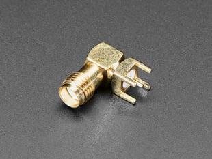 Angled shot of small, metallic, right angle SMA connector.