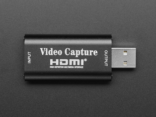 Overhead shot of black USB-A-to-HDMI video capture adapter.