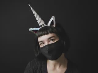 Woman with assembled DIY Be a Unicorn Light-Up Unicorn Headband Kit posing