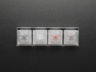Top view of video of a blue manicured finger pressing each of the four key switches.