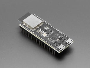 Angled shot of black rectangular microcontroller with Wi-Fi module and pre-soldered headers.