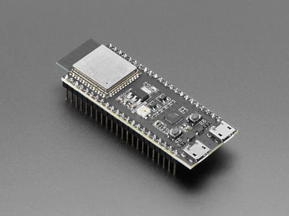 Angled shot of black rectangular microcontroller with Wi-Fi module and pre-soldered headers.