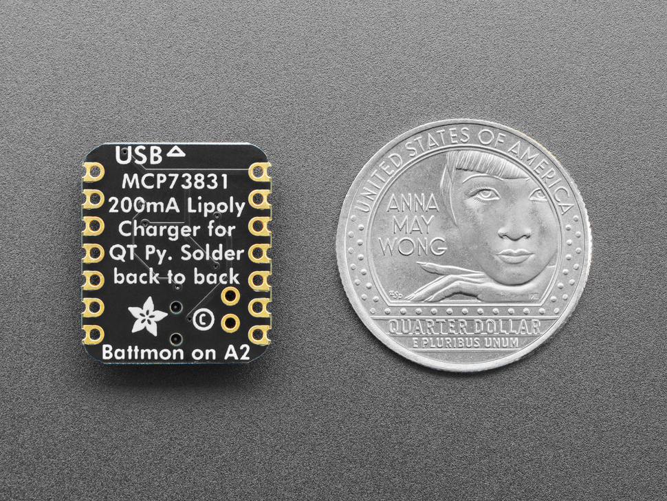 back of small, black, square-shaped breakout board next to US quarter for scale