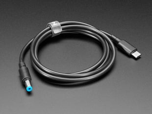 Angled shot of a coiled DC barrel jack to USB-C cable.