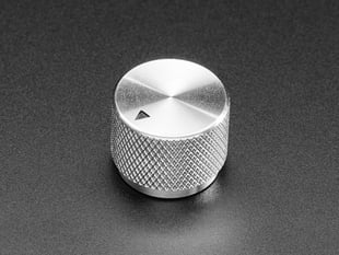 Angled shot of a black aluminum knob. A black triangle on top of the knob points at 7:00. 