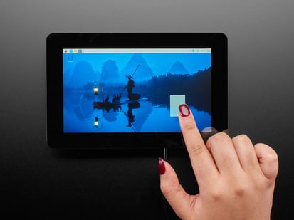 Overhead shot of a Black hand with red manicure drawing a rectangle on a touchscreen landscape-style.