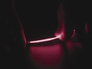 Video of Black hand articulating red LED filament.