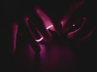 Video of Black hand articulating pink LED filament.