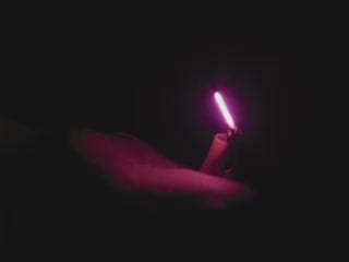 Video of Black hand articulating pink LED filament.