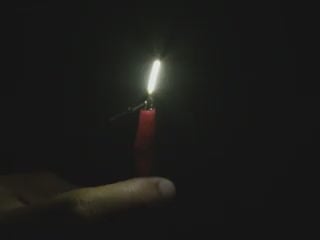 Black hand articulating short natural white LED filament.