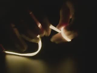 Video of Black hand articulating white LED filament.