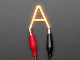 Overhead shot of LED in the shape of the letter "A" lit up with alligator clips.