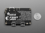 Back of black, credit card-sized microcontroller with U.S. quarter for scale.