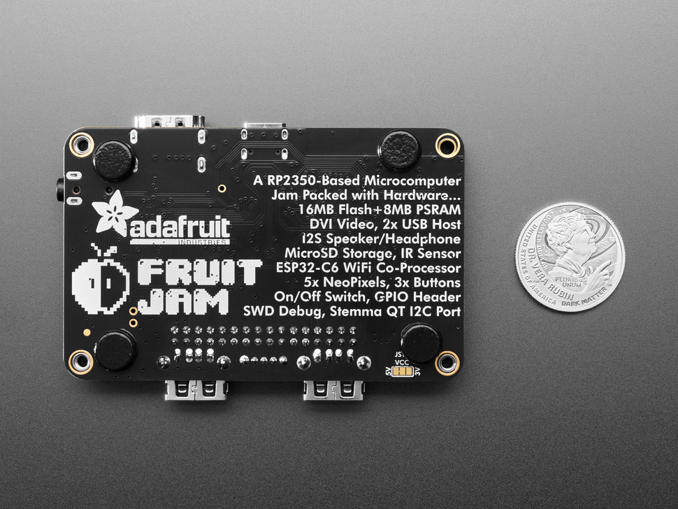 Back of black, rectangle PCB with four black rubber bumper feet.