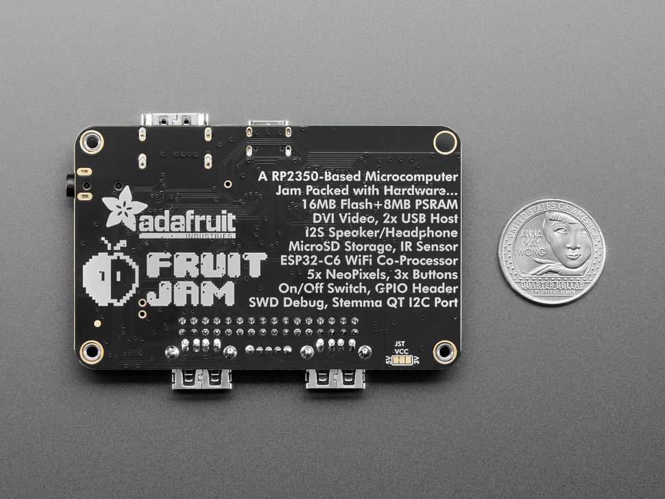 Back of black, credit card-sized microcontroller with U.S. quarter for scale.