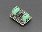 Angled shot of rectangular, black, LED driver board with green terminal blocks.