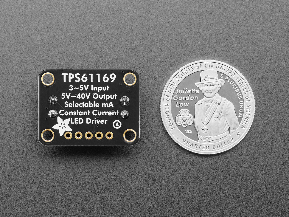 Bottom of black, rectangular LED driver board with U.S. Quarter for Scale.