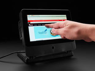 Hand pointing to a touchscreen enclosure.