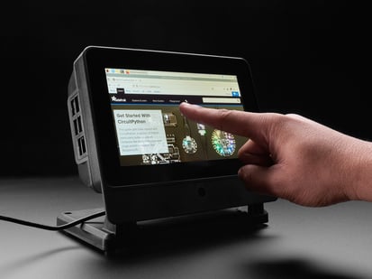 Hand pointing to a touchscreen enclosure.