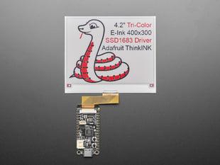 Angled shot of 4.2" tri-color electronic ink display showing a friendly python: "4.2" Tri-Color E-Ink 400x300 SSD1683 Driver Adafruit ThinkInk"
