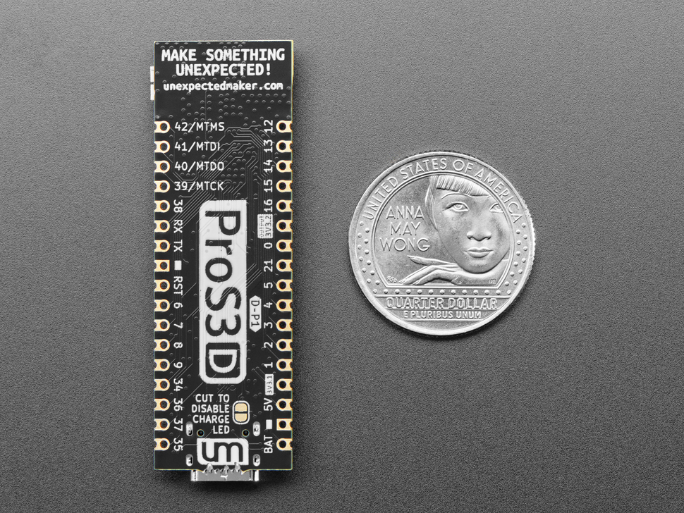 Back of long, black, skinny, dev board with U.S. quarter for scale.
