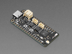 Angled shot of black, rectangular Feather microcontroller.