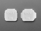 Overhead shot of two pieces of white plastic square-shaped enclosure pieces.