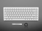 Top Down Top Shot of the Raspberry Pi 500+ wit Keycap Removal & Key Board Opening Tools.