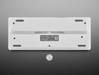 Top Down Bottom Shot of the Raspberry Pi 500+ next to a U.S. Quarter for Scale.