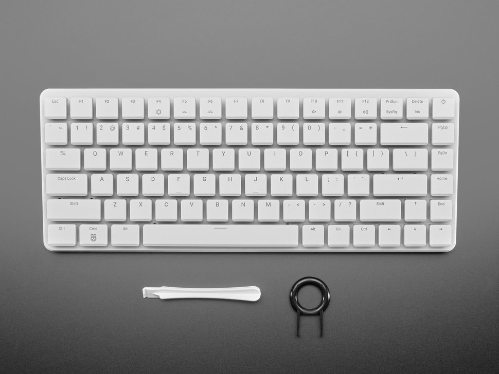 Top Down Top Shot of the Raspberry Pi 500+ wit Keycap Removal & Key Board Opening Tools.