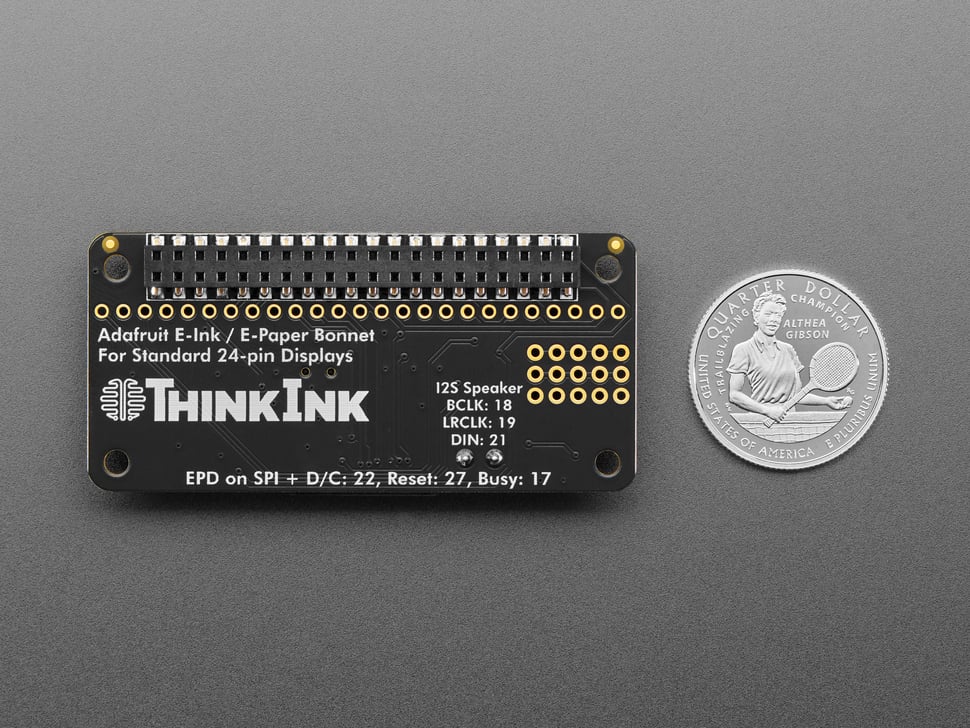 Back of black, rectangle-shaped PCB with U.S. quarter for scale.