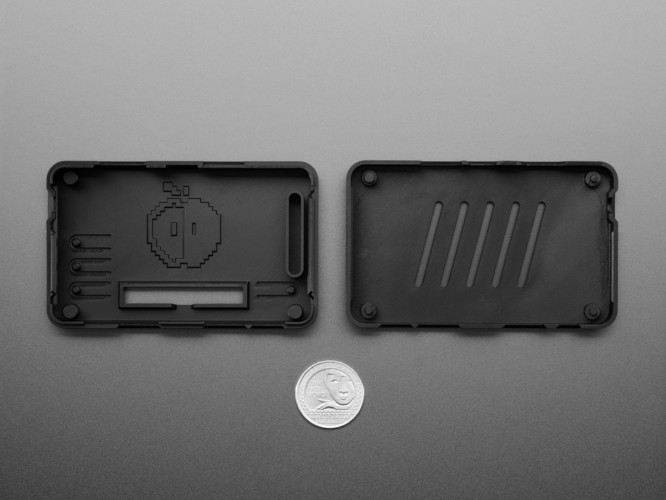 Top Down Shot of the Interior Side to the top and bottom of the Snap-on Enclosure next to a U.S. Quarter for Scale.