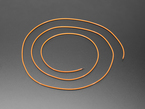 Angled shot of long, orange LED filament coiled.